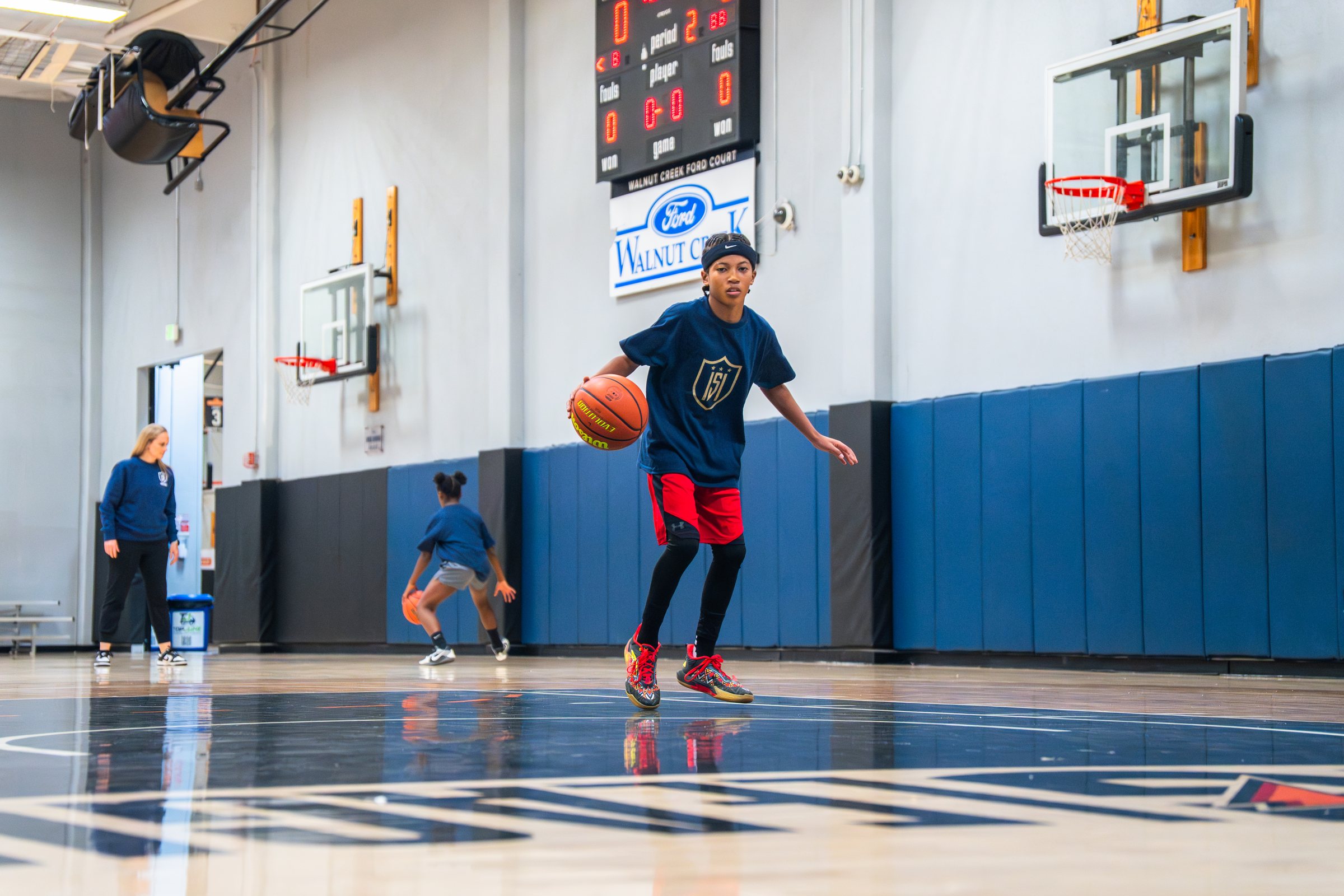 A young basketball player driving toward the hoop during an ISI Academy practice.